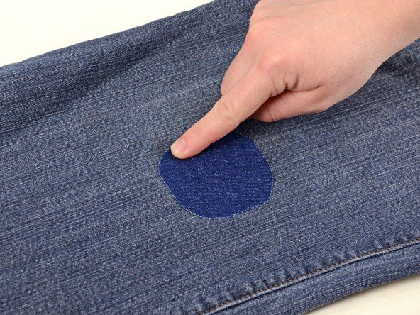 パッチの端に指をかけて、すべての端がジーンズに完全に接着していることを確認します。' alt=