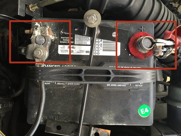 車のバッテリーの上部にある端子を見つけます。各端子の横には、電荷を示す正（+）または負（-）の記号があります。' alt=