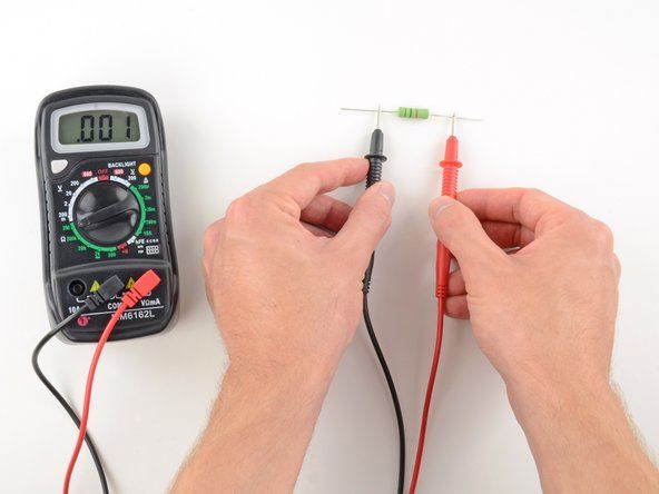 テストする回路またはコンポーネントの両端に1つのプローブを配置します。' alt=