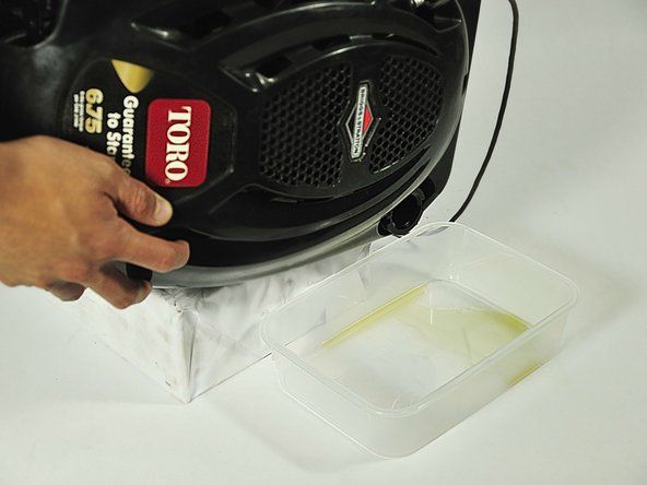 Para remover o óleo, incline o cortador de lado e despeje o óleo velho em um recipiente adequado.' alt=