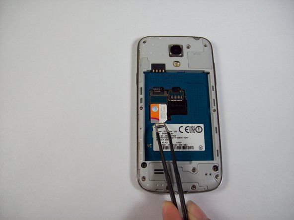 Используя пинцет, извлеките SIM-карту, сдвинув ее к нижней части устройства.' alt=