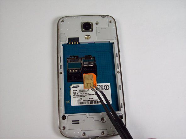 Utilizzando le pinzette, rimuovere la scheda SIM facendola scorrere verso la parte inferiore del dispositivo.' alt=