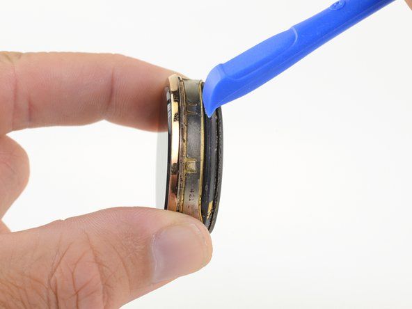 指の爪またはオープニングツールを使用して、プラスチック製の下部アセンブリをディスプレイアセンブリからこじ開けます。' alt=