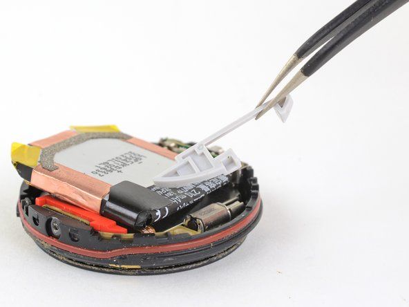 ピンセットを使用して、バッテリーコネクタの上の灰色のプラスチックカバーを持ち上げます。' alt=