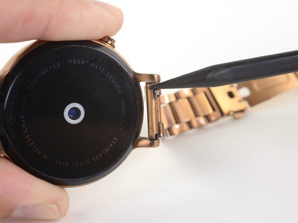 指またはスパッジャーの先端を使用して、時計バンドを固定しているピンを圧縮します。' alt=