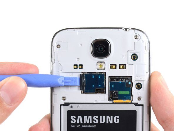 Bruk den flate enden av en spudger, eller neglen, til å trykke microSD-kortet litt dypere inn i sporet til du hører et klikk.' alt=