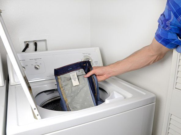 Поместите джинсы в стиральную машину.' alt=