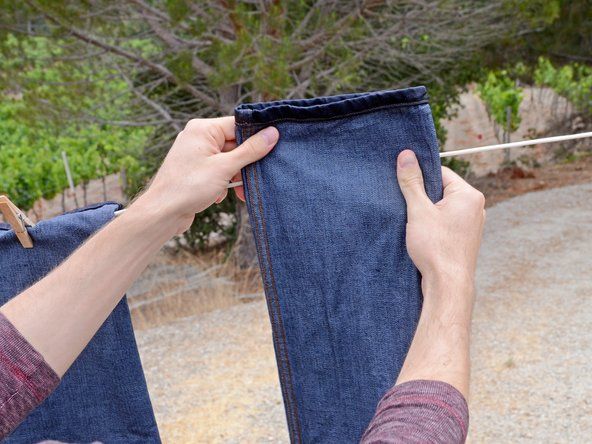 Возьмите вторую штанину и сложите манжету по линии, как делали раньше. Распределите эту манжету так, чтобы джинсы свисали как можно более плоско.' alt=