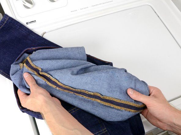 Выверните джинсы наизнанку, протянув края каждой штанины за пояс.' alt=