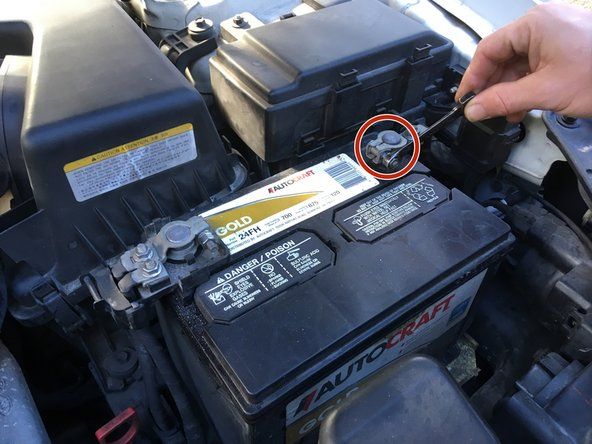 Individuare la batteria dell'auto e utilizzare il cricchetto per allentare il cavo negativo (-).' alt=