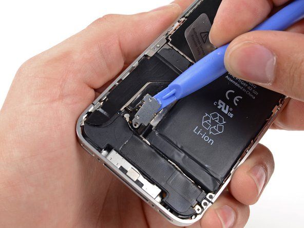 Usa uno strumento di apertura in plastica per sollevare delicatamente il connettore della batteria dal suo zoccolo sulla scheda logica.' alt=
