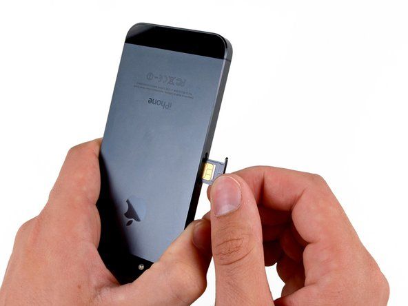 Ta bort SIM-kortsfacket från iPhone.' alt=