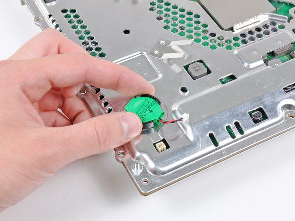Xoay nhẹ pin PRAM ngược chiều kim đồng hồ và tháo pin ra khỏi cụm bo mạch chủ.' alt=