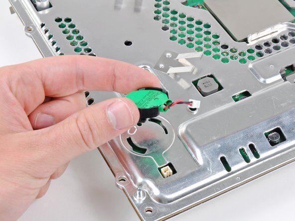 Xoay nhẹ pin PRAM ngược chiều kim đồng hồ và tháo pin ra khỏi cụm bo mạch chủ.' alt=