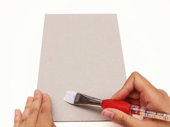 Gunakan berus cat untuk melekatkan gam pengikat buku pada penutup dan tulang belakang.' alt=