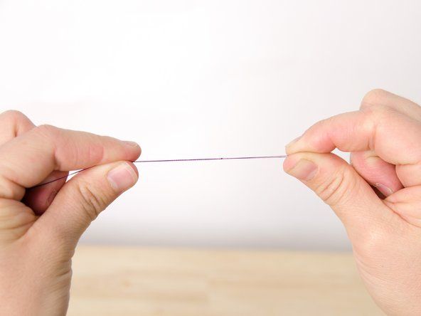 Dette fanger nålen i trådløkken og lar deg sy med dobbel tråd. Hvis du foretrekker å sy med en enkelt tråd, knytter du bare en av trådene, ikke begge.' alt=