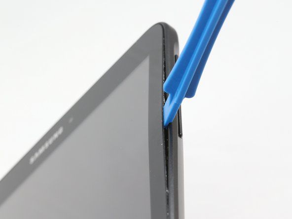 Medzi sklenený displej a okraj tabletu vložte jeden z modrých plastových otváracích nástrojov' alt=