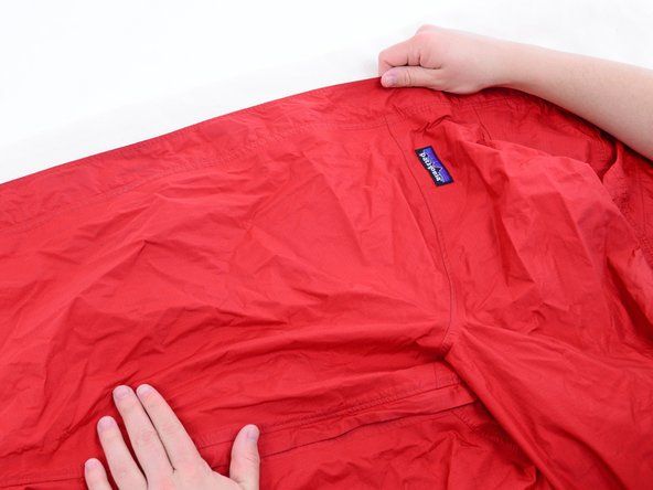 Décompressez votre veste propre et faites-en glisser une moitié sur votre planche à repasser.' alt=