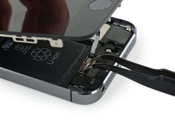 Semasa pemasangan semula, anda perlu memasang semula pendakap kabel Touch ID. Bahagian atas pendakap perlu meluncur antara bateri dan penyambung kabel Touch ID, di hadapan tab logam. Bahagian bawah mesti terkunci di atas penyambung.' alt=