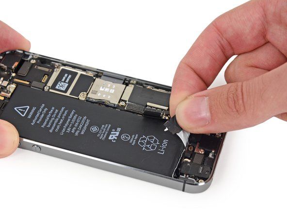 Tarik perlahan-lahan salah satu jalur pelekat bateri dari bateri, ke arah bawah iPhone. Tarik bahagian putih jalur jika boleh, tab hitam mungkin jatuh.' alt=