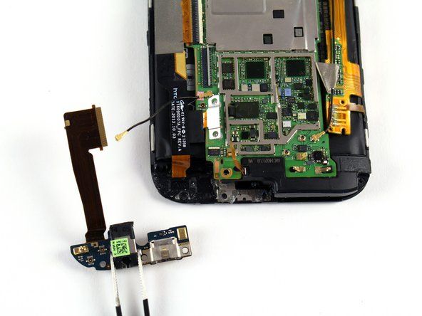 Kasutage kõrvaklappide pesa / mikro-USB-plaadi õrnalt telefonist üles ja välja tõmbamiseks pintsetti või plastist avamistööriista.' alt=