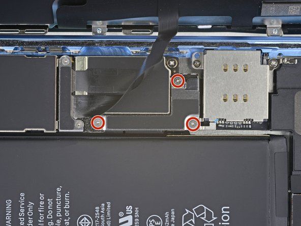 Vyšroubujte tři šrouby 1,2 mm Y000 zajišťující držák krytu konektoru baterie.' alt=