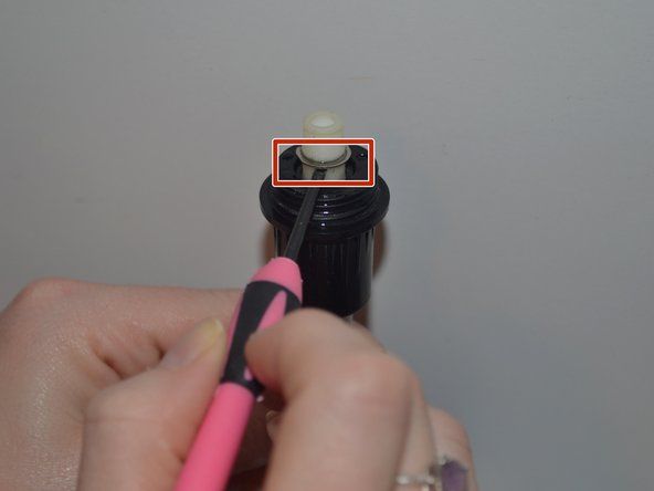 Verwijder de c-clip die zich op het uittrekbare aansluitpunt van het spuitapparaat bevindt met een kleine platte schroevendraaier.' alt=