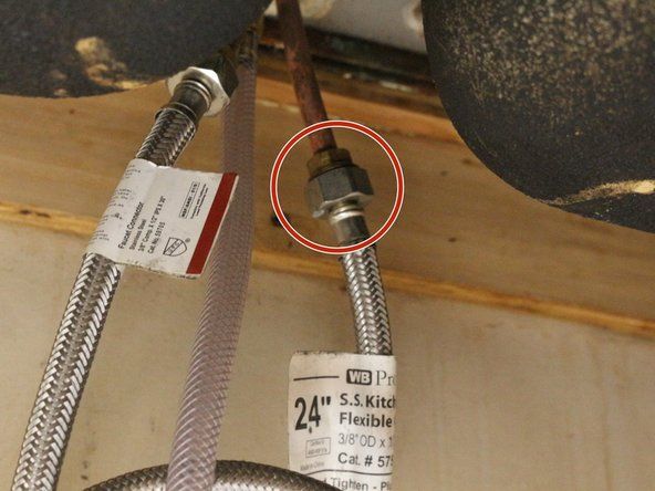 シンクの上からシンクの蛇口スプレーヘッドを引っ張って、シンクの下にある給水管へのメインホース接続ポイントを見つけます。' alt=