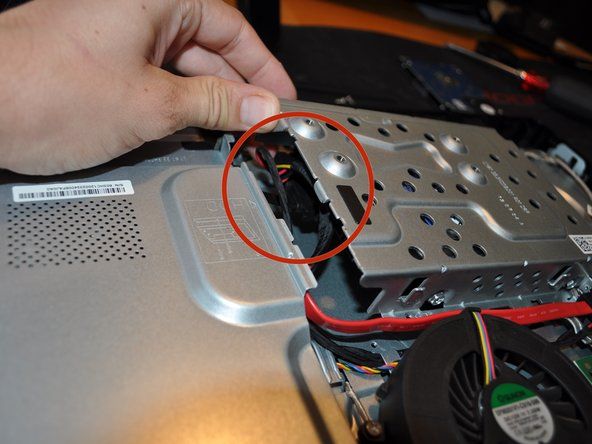 Schieben Sie den Festplattenkäfig leicht heraus, um auf das Strom- und SATA-Kabel zuzugreifen und es zu entfernen.' alt=