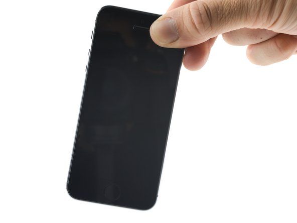 Țineți telefonul în poziție verticală și înclinați-l ușor dintr-o parte în alta pentru a scurge cât mai mult lichid prin fund.' alt=
