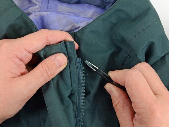 Pomocí pinzety odstraňte všechny zbývající části zarážky z oděvu.' alt=