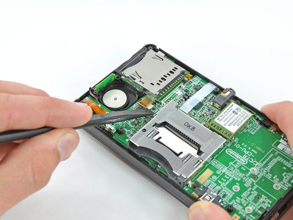 Pomocí plochého konce spudgeru vypáčte konektor plochého kabelu SD karty ze zásuvky na základní desce.' alt=