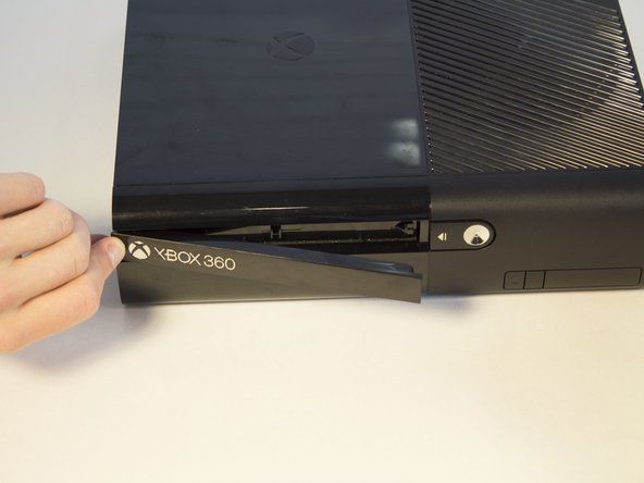 Kompaktdisku priekšā atradīsit Xbox logotipu. Nospiediet laukumu pa kreisi no Xbox logotipa, un diska paliktņa panelis parādīsies.' alt=