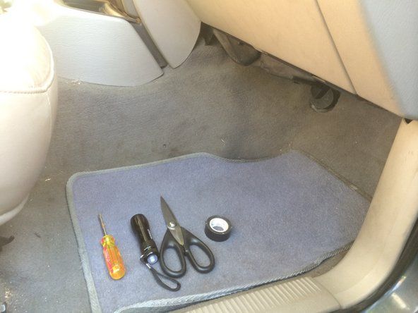 वायरिंग तक आसान पहुंच के लिए सीट को पीछे धकेलें, और अपने उपकरणों को कार के फर्श पर रखें।' alt=