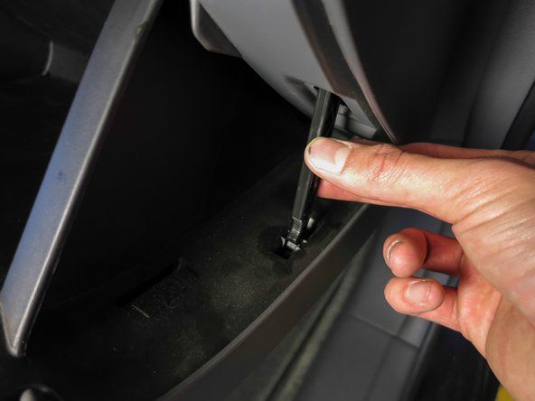 Lossa spärren från handskfacket genom att trycka den mot framsidan av bilen.' alt=