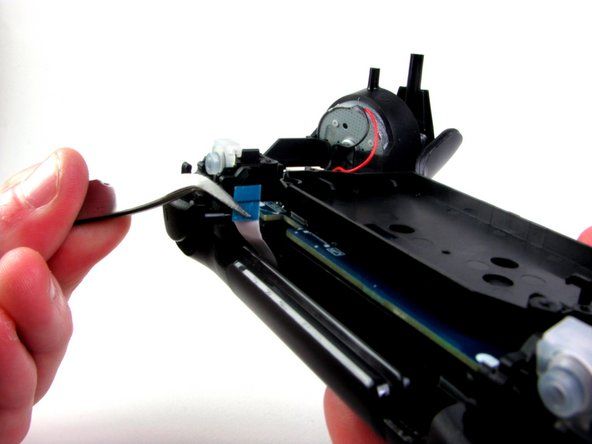 Nhẹ nhàng tháo dải băng của bàn di chuột được kết nối với bo mạch chủ bằng cách sử dụng kẹp cùn. Ruy-băng của bàn di chuột được kết nối với bo mạch chủ bằng một đầu nối có thể lật để thắt chặt và nới lỏng. Trong quá trình lắp ráp lại, để gắn lại dải băng, bạn cần nhẹ nhàng tháo khay nhựa ra khỏi bo mạch chủ và lật khóa lật lên.' alt=