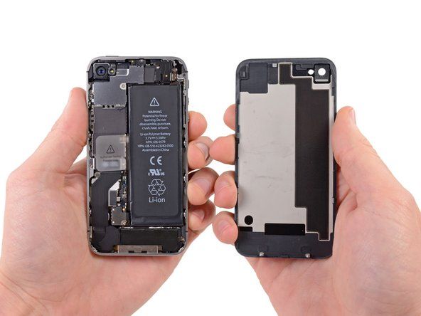 Trek het achterpaneel weg van de achterkant van de iPhone en zorg ervoor dat u de plastic clips op het achterpaneel niet beschadigt.' alt=