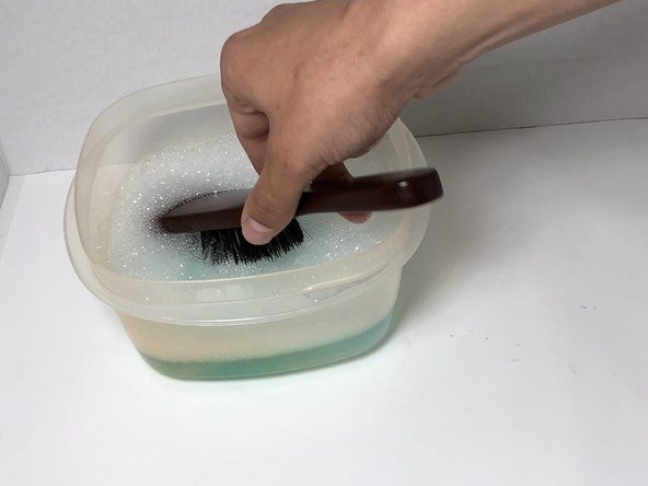 비누와 물이 섞인 부드러운 강모 브러시를 사용하여 신발 바닥의 먼지를 닦아냅니다.' alt=