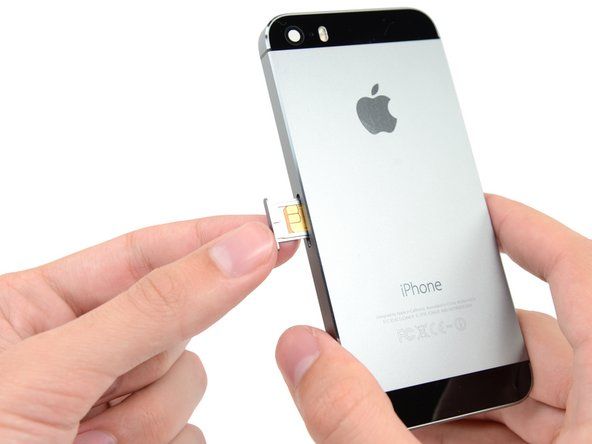 Vyjměte sestavu přihrádky na SIM kartu z iPhone.' alt=