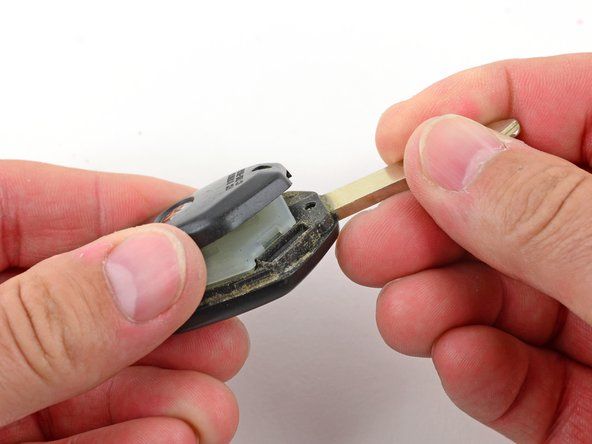 İki siyah plastik parça, kontrol modülünü ortaya çıkaracak şekilde ayrılmalıdır. Kontrol modülünü anahtarın geri kalanından kaldırın.' alt=