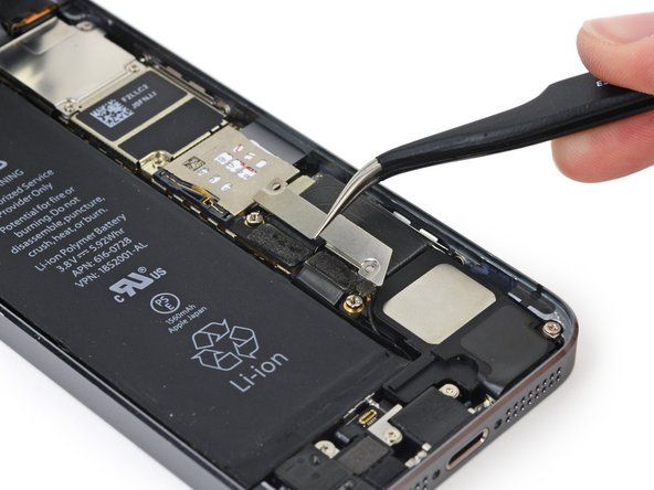 Отстранете металната скоба на съединителя на батерията от iPhone.' alt=