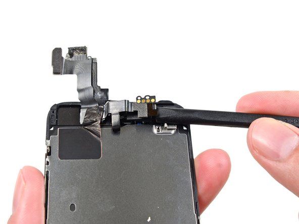 Използвайте плоския край на пулверизатора, за да отлепите внимателно предната част на камерата от кабела далеч от модула на дисплея.' alt=