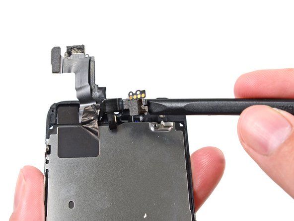 Използвайте плоския край на пулверизатора, за да отлепите внимателно предната част на камерата от кабела далеч от модула на дисплея.' alt=