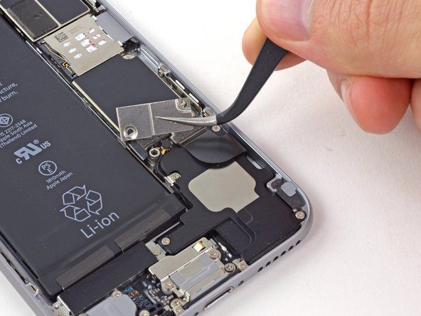 Verwijder de metalen batterijconnectorbeugel van de iPhone.' alt=