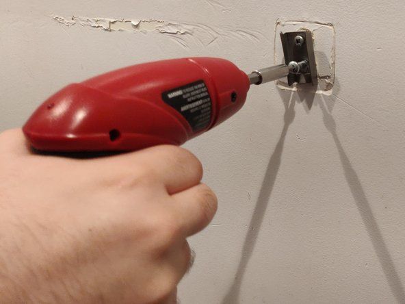 Kun olet irrottanut pidikkeen, ota se pois ja aloita ruuvien avaaminen seinässä. Ruuvimeisselin tyyppi riippuu käytetyistä ruuveista.' alt=