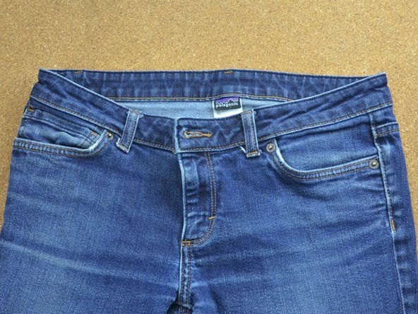 Letakkan seluar jeans anda ke depan di atas meja atau meja kerja yang kukuh.' alt=