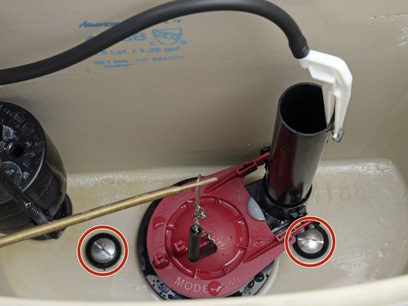Używając klucza nasadowego do przytrzymania nakrętek, odkręć dwie śruby zbiornika za pomocą śrubokręta.' alt=