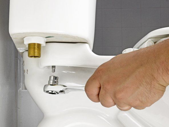 Podczas ponownego mocowania zbiornika dokręć śruby śrubokrętem, zamiast dokręcać nakrętki. Naprzemiennie dokręcaj każdą śrubę stopniowo, aż zbiornik będzie ściśle przylegał do toalety.' alt=