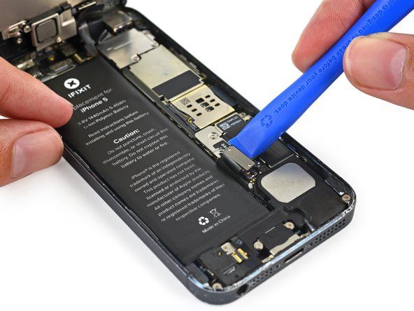 Verwenden Sie ein Kunststoff-Öffnungswerkzeug, um den Batteriestecker vorsichtig aus der Buchse auf der Hauptplatine herauszuhebeln.' alt=