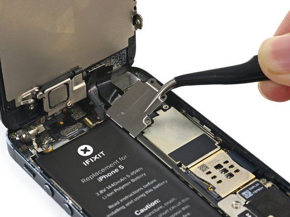 Podnieś wspornik kabla wyświetlacza w stronę baterii, aby ją odczepić, i wyjmij ją z iPhone'a.' alt=